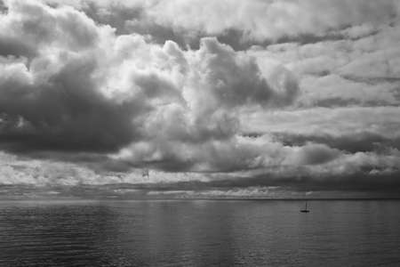 A morning shot over looking the Pacific Ocean after a storm in Newport Beach with a lone sailboat in...