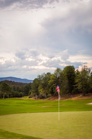 A close up shot of a golf course green with a American Flag for the pin flag の写真素材