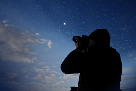 silhouette of photographer shooting night stars の写真素材