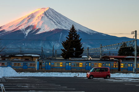 Fujikawaguchiko, Japan - February 10, 2016: The Fujikyu commuter train is parking on platform at Kawaguchiko station with morning mount Fuji on background.のeditorial素材
