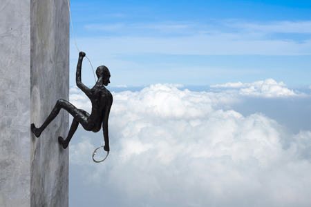 abstract background, clay doll climbing the wall and looking over to the skyの写真素材