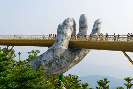 Danang, Vietnam - Mar. 29, 2019: The Golden Bridge âgiant hands of Godsâ. The two giant colossal hands emerging from the mountains holding up the golden bridge at the height of 1,414 m from the sea level in the Ba Na Hills, Da Nang, Vietnam.のeditorial素材