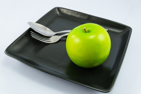 Apple on dish with white backgrounds.の写真素材