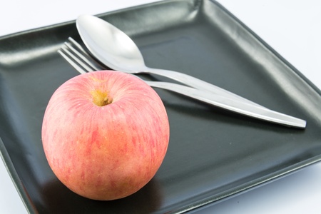 Apple on dish with white backgrounds.の写真素材