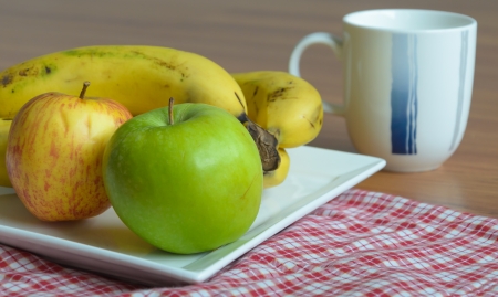 Green&Red apple with banana on white dishの写真素材