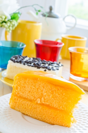 Orange cake in white dish on the wood tableの写真素材