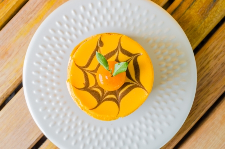 Orange Cake in white dish on the wood tableの写真素材