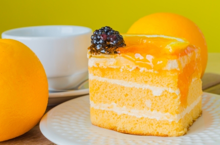 Orange Cake in white dish on the wood tableの写真素材