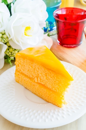 Orange cake in white dish on the wood tableの写真素材