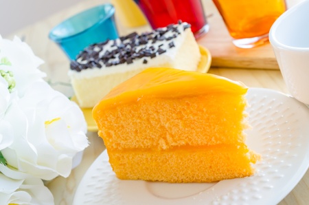 Orange cake in white dish on the wood tableの写真素材