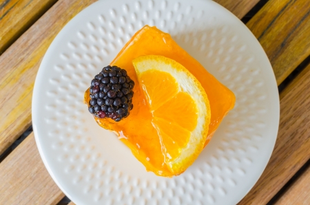 Orange Cake in white dish on the wood tableの写真素材