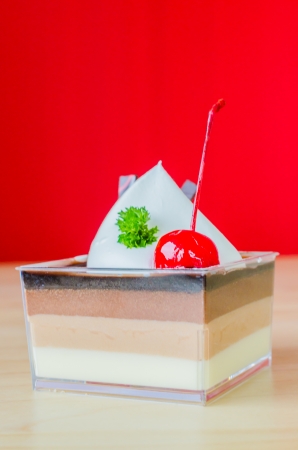Vanilla , Chocolate , Coffee layer cake with cherry on top and colorful backgroundの写真素材