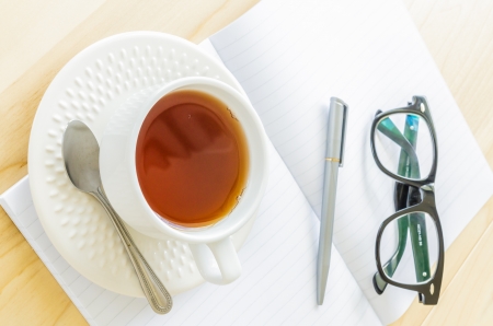 Paper note with eye glasses&white cupteaの写真素材