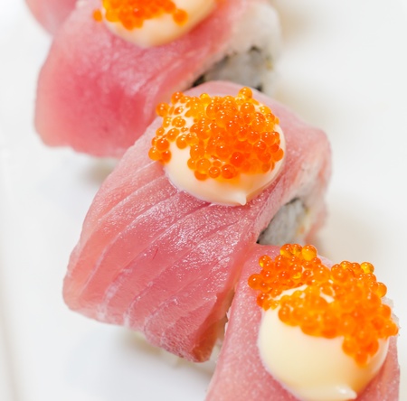 Tuna sushi with avocado inside on white dishの写真素材