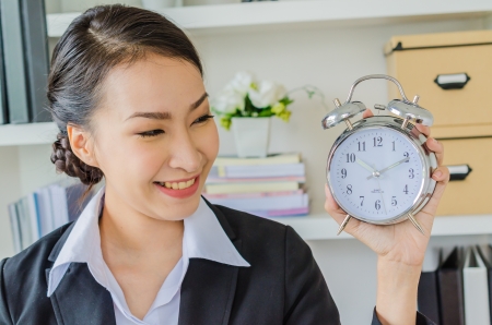 Young business woman with clockの写真素材