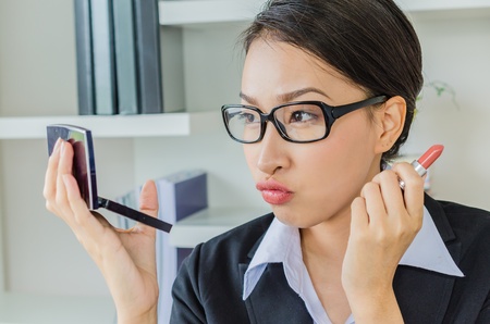 Young business women make up her face in officeの写真素材
