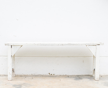 White bench on the white concrete wallの写真素材