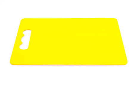 Yellow plastic cutting board on isolated white backgroundの写真素材