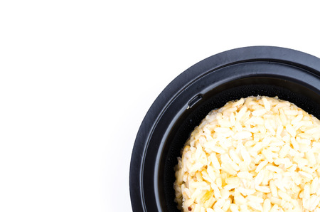 Brown rice in black bowl on white dishの写真素材