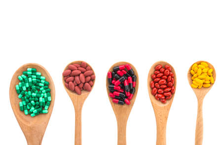 Pill on spoon isolated on white backgroundの写真素材