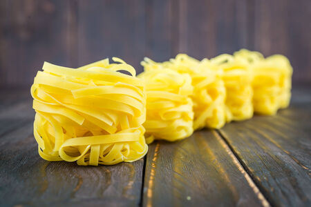 Raw pasta on wooden background - process old dark style pictureの写真素材