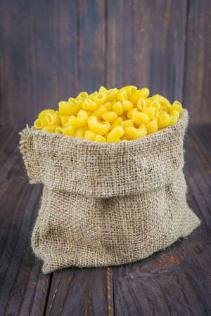 Raw pasta on wooden background - process old dark style pictureの写真素材