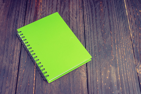 Note book on wooden background - vintage effect style pictureの写真素材