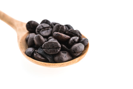Coffee beans in wooden spoon isolated on white backgroundの写真素材