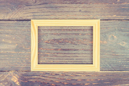 frame on wooden background - vintage style effect pictureの写真素材