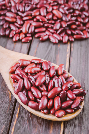 Red beans in wooden spoon on wooden backgroundの写真素材