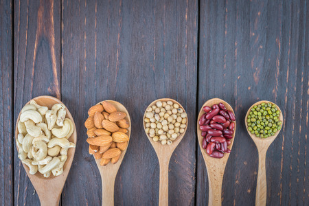 Beans on spoon on wooden background - vintage style picture