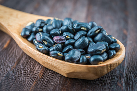 Black beans on wooden background - vintage effect style picturesの写真素材
