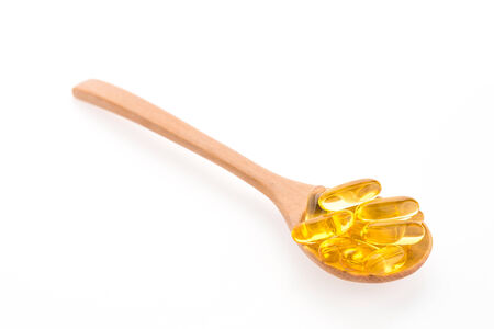 Fish oil in wooden spoon isolated on white backgroundの写真素材