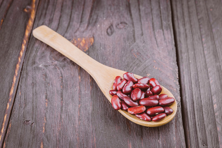 Red beans in wooden spoon on wooden backgroundの写真素材