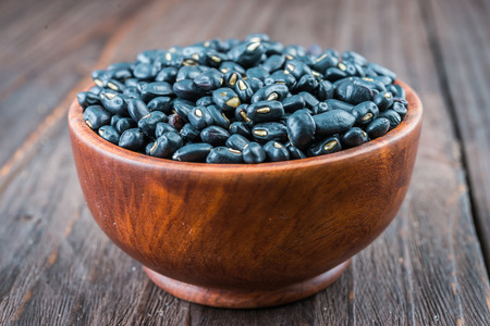 Black beans on wooden background - vintage effect style picturesの写真素材