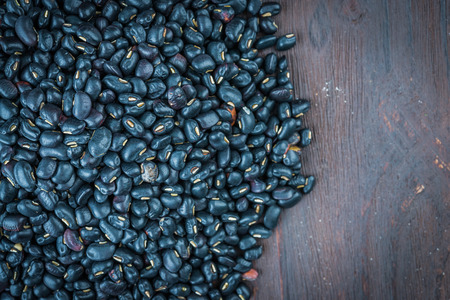 Black beans on wooden background - vintage effect style picturesの写真素材