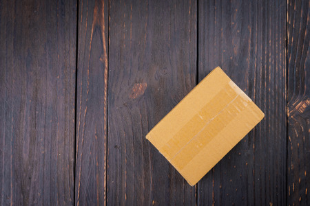 Box on wooden background - old dark effect style pictureの写真素材