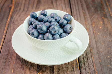 Blueberry cup on wooden background - vintage effect style picturesの写真素材