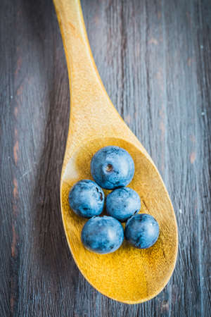 Blueberry spoon on wooden background - vintage effect style picturesの写真素材