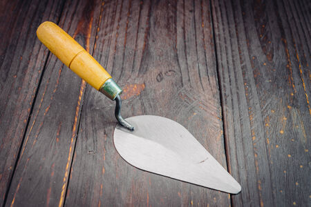 Trowel on wooden background - vintage effect style picturesの写真素材