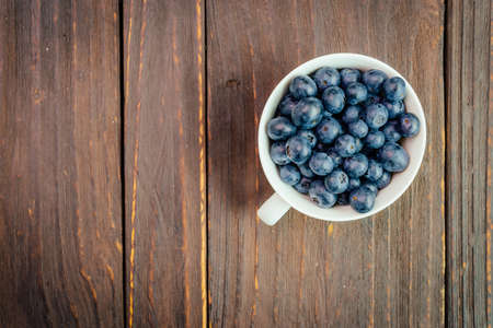 Blueberry cup on wooden background - vintage effect style picturesの写真素材
