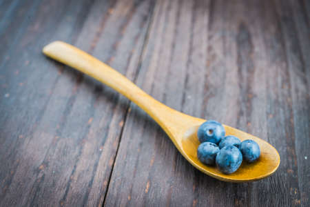 Blueberry spoon on wooden background - vintage effect style picturesの写真素材