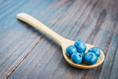 Blueberry spoon on wooden background - vintage effect style picturesの写真素材