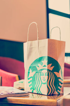 Bangkok ,Thailand- OCT 29 : Starbuck paper bag on wood table in starbuck shop at The Walk Department store Ratchapruek, Bangkok, Thailand.のeditorial素材