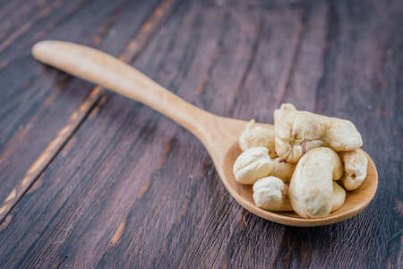 Cashew on spoon on wooden background - vintage effect style picturesの写真素材