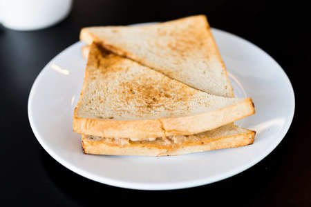 Tuna Sandwich in white plate on black tableの写真素材