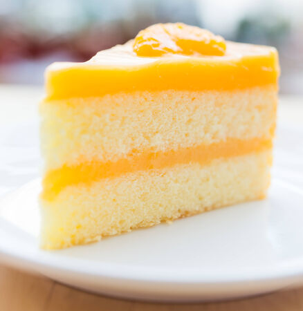 Orange cakes in white plate on wooded tableの写真素材