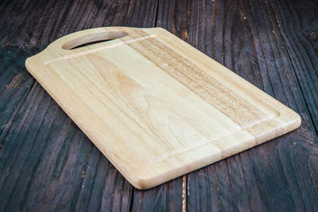 Cutting board on wooden background - old style picture process