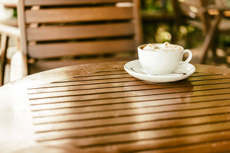Latte coffee mug on wooden table - vintage effect style picturesの写真素材