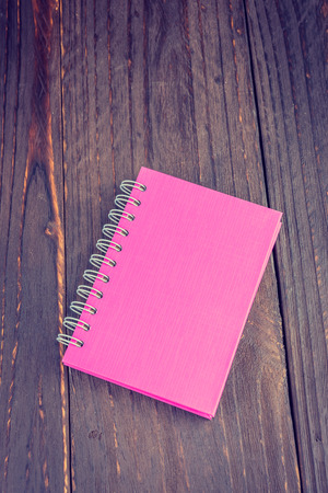 Note book on wooden background - vintage effect style pictureの写真素材